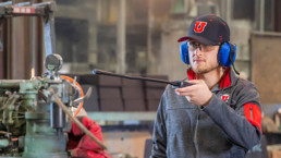 a University of Utah student rinsing off a piece of machinery