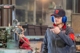 a University of Utah student rinsing off a piece of machinery
