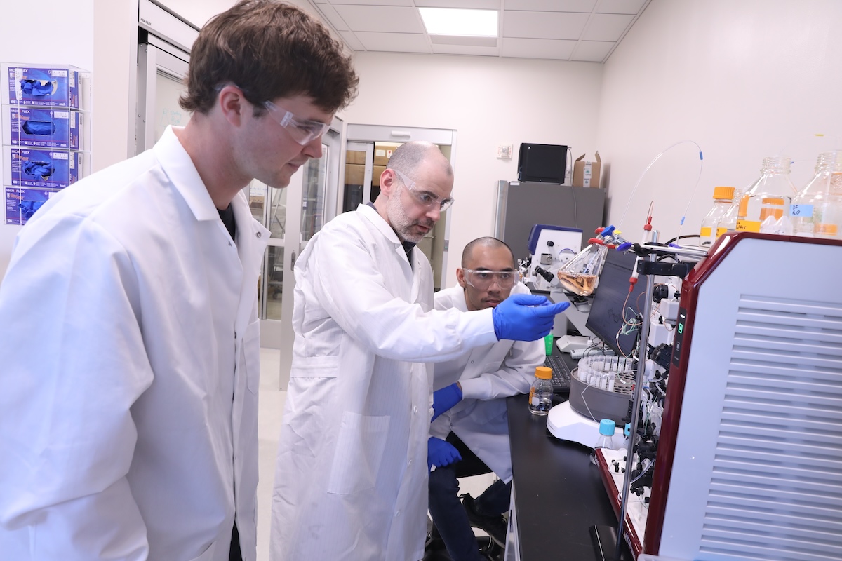 Researchers attend to a complicated machine