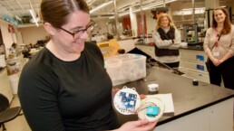 Tristalee Mangin shows off the circuitry of an atmospheric sensor
